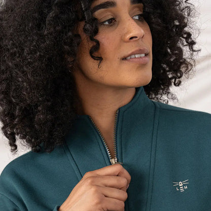 Lighthouse Ladies Coral Jersey featuring a woman in a dark teal jacket with embroidered logo