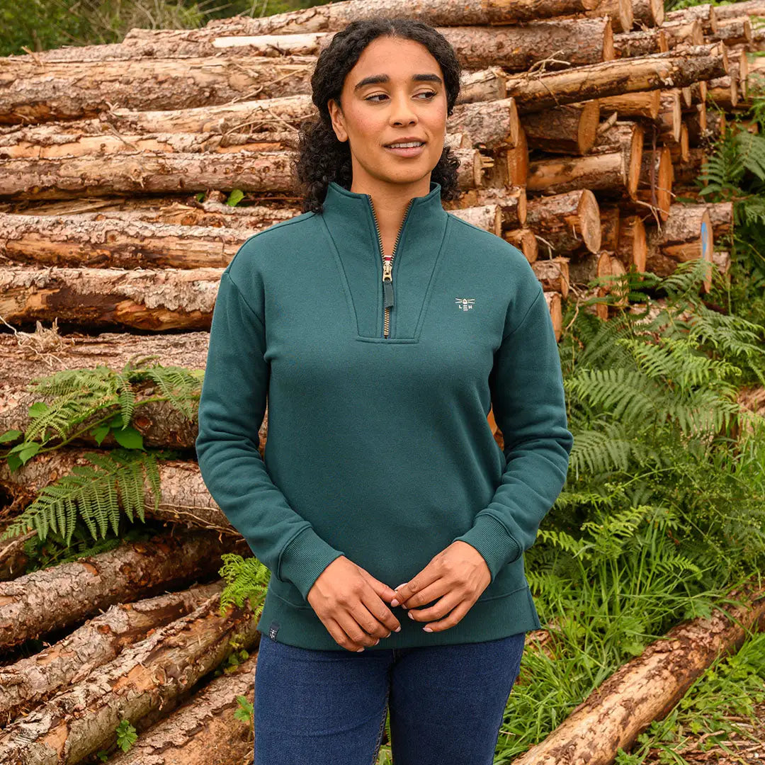 Woman modeling Lighthouse Ladies Coral Jersey dark teal quarter-zip sweatshirt with embroidered emblem