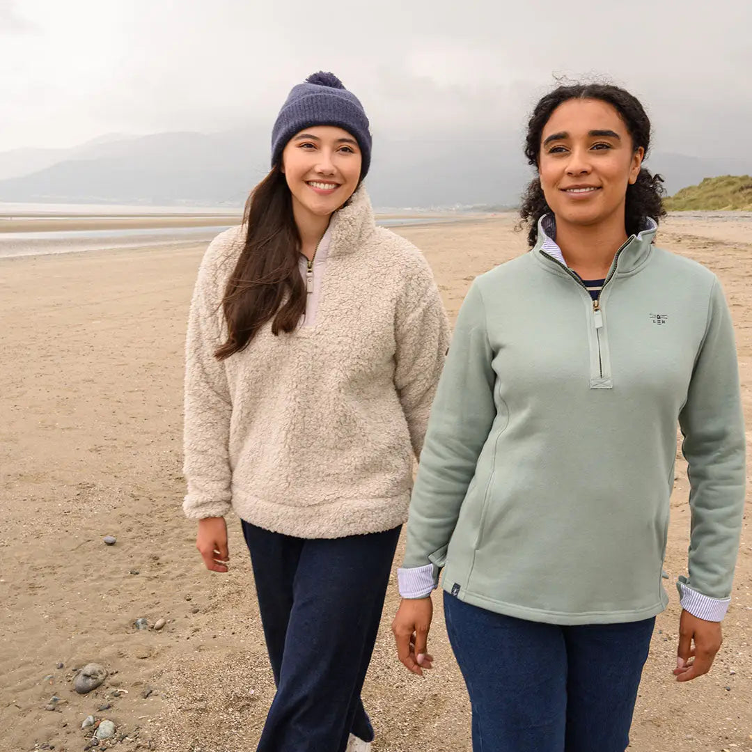 Lighthouse Ladies Half-Zip Coast Fleece women walking on sandy beach in comfy quarter-zip