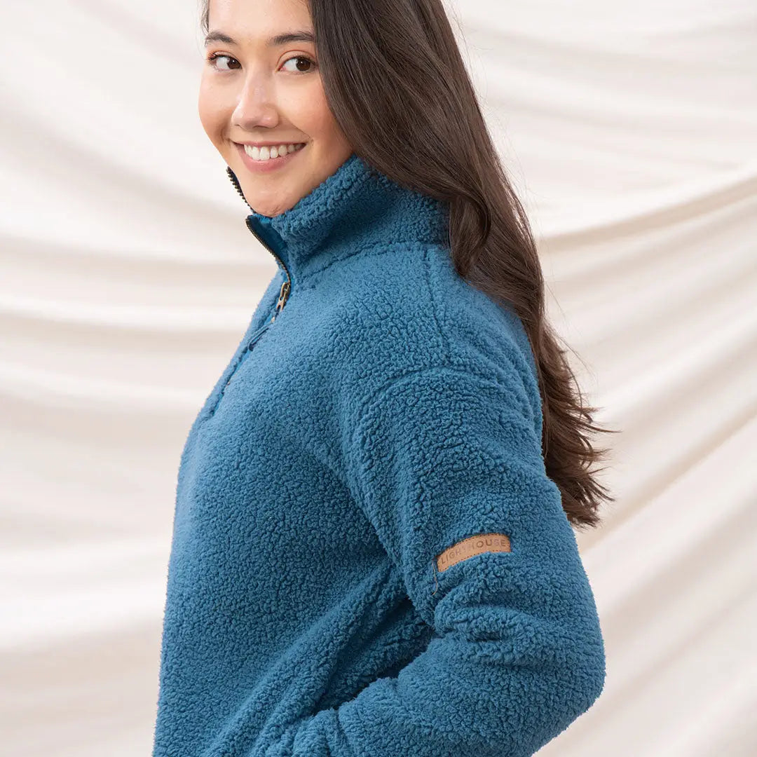 Smiling woman wearing Lighthouse Ladies Coast Fleece Half-Zip in blue sherpa fleece