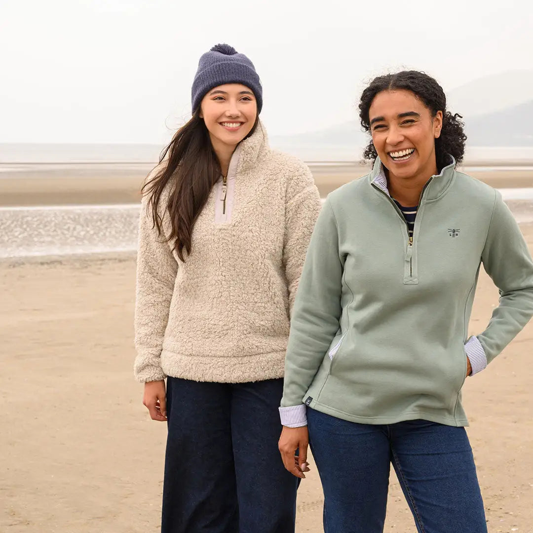 Two women wearing Lighthouse Ladies Coast Fleece half-zip pullovers on the beach