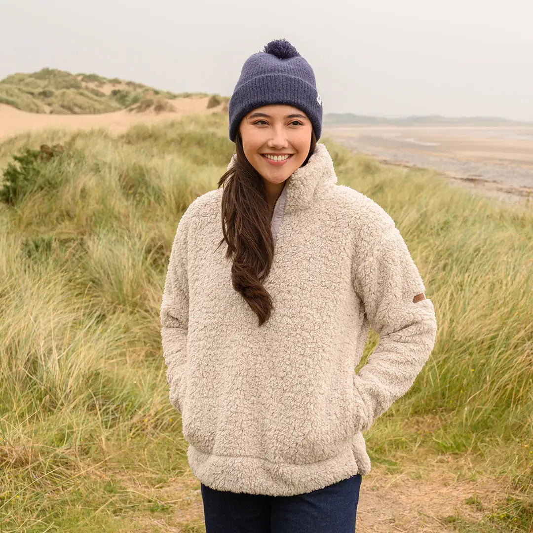 Young woman in Lighthouse Ladies Coast Fleece half-zip with cream fleece and navy beanie