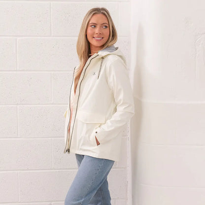 Woman in a white raincoat and jeans wearing the Lighthouse Ladies Lucy Coat