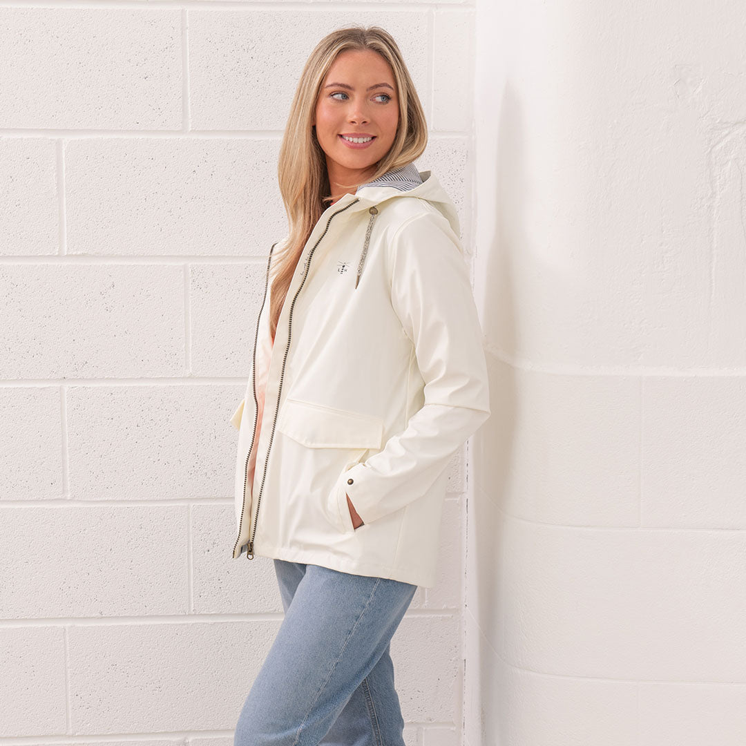 Woman in a white raincoat and jeans wearing the Lighthouse Ladies Lucy Coat