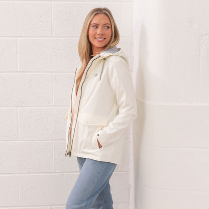 Woman in a white raincoat and jeans wearing the Lighthouse Ladies Lucy Coat
