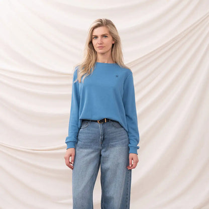 Woman in blue sweater and wide-leg jeans wearing a Lighthouse Ladies Seaside Jersey