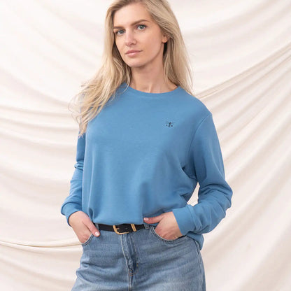 Woman in a blue sweatshirt from the Lighthouse Ladies Seaside collection