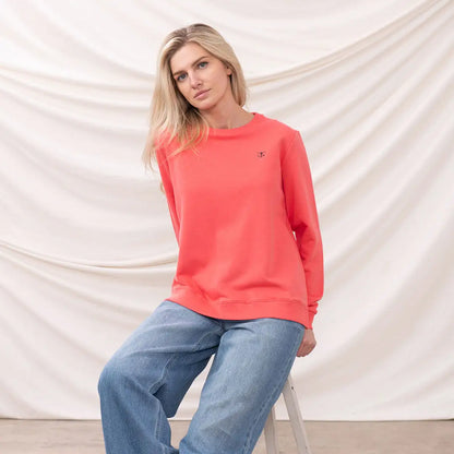 Woman in coral sweatshirt and blue jeans wearing Lighthouse Ladies Seaside Jersey