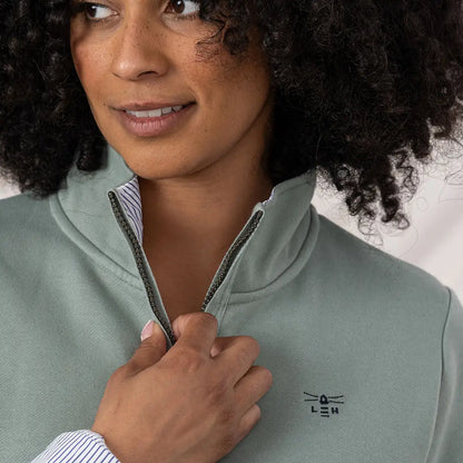 Woman zipping up Lighthouse Ladies Shore II Jersey sweatshirt with striped collar lining