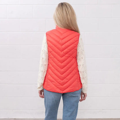 Woman in a coral puffer vest from Lighthouse Laurel, perfect for country clothing and hunting