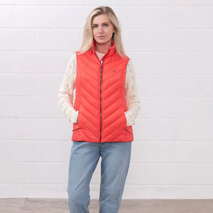 Woman in a coral puffer vest from the Lighthouse Laurel ladies collection