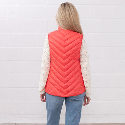 Woman in a coral puffer vest from Lighthouse Laurel, perfect for country clothing and hunting