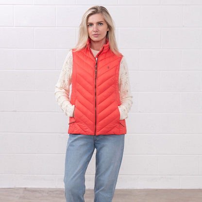 Woman in a coral puffer vest from the Lighthouse Laurel ladies collection