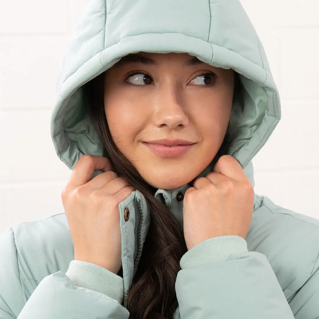 Woman in light green Lighthouse Margot Ladies Coat with hood for stylish winter look