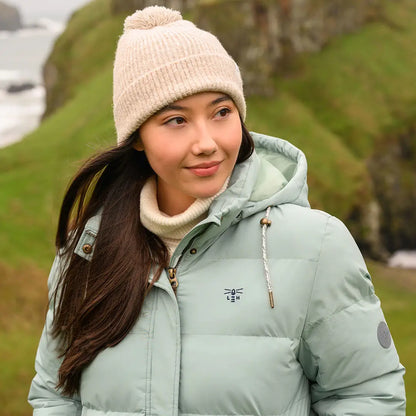 Woman in light green Lighthouse Margot Ladies coat with hood and cream knit beanie