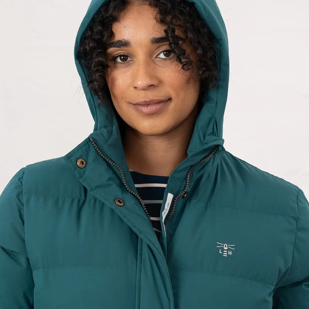 Woman in teal hooded puffer jacket showcasing the Lighthouse Savannah Coat on a model