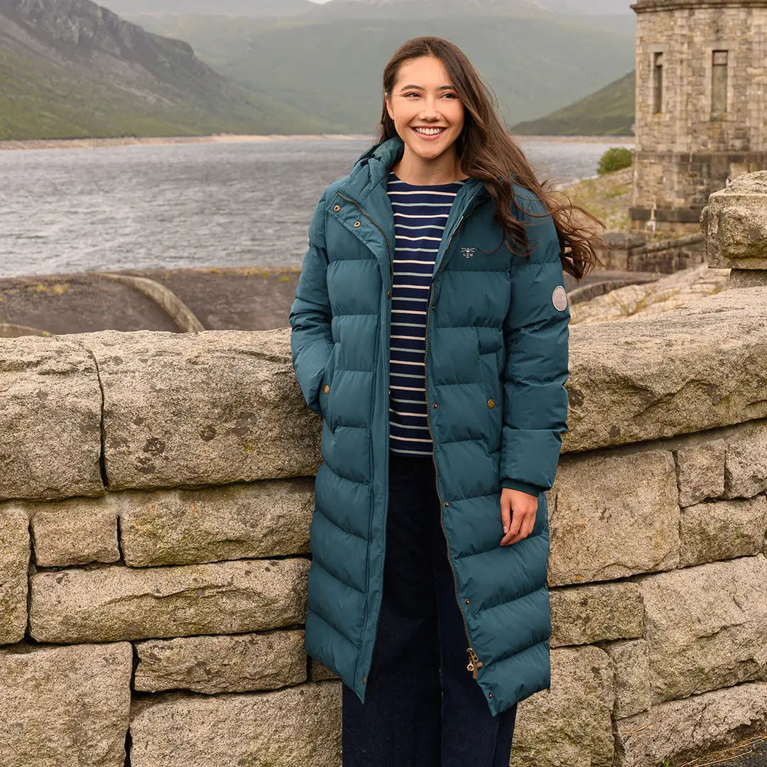 Young woman in teal Lighthouse Savannah Coat and striped shirt outdoor style
