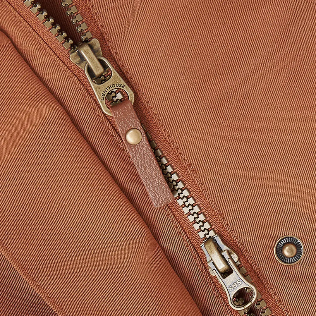 Close-up of Lighthouse Scarlet Ladies Coat zipper with brass pull, perfect for outdoor country clothing and hunting