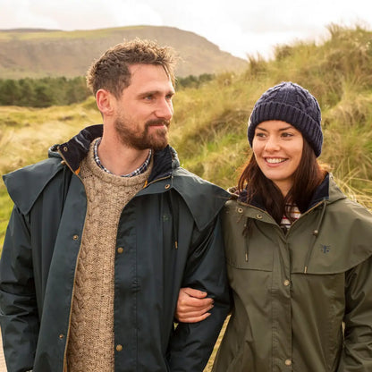 Couple in outdoor gear, showcasing the Lighthouse Stockman Full Length Waterproof Rain Coat