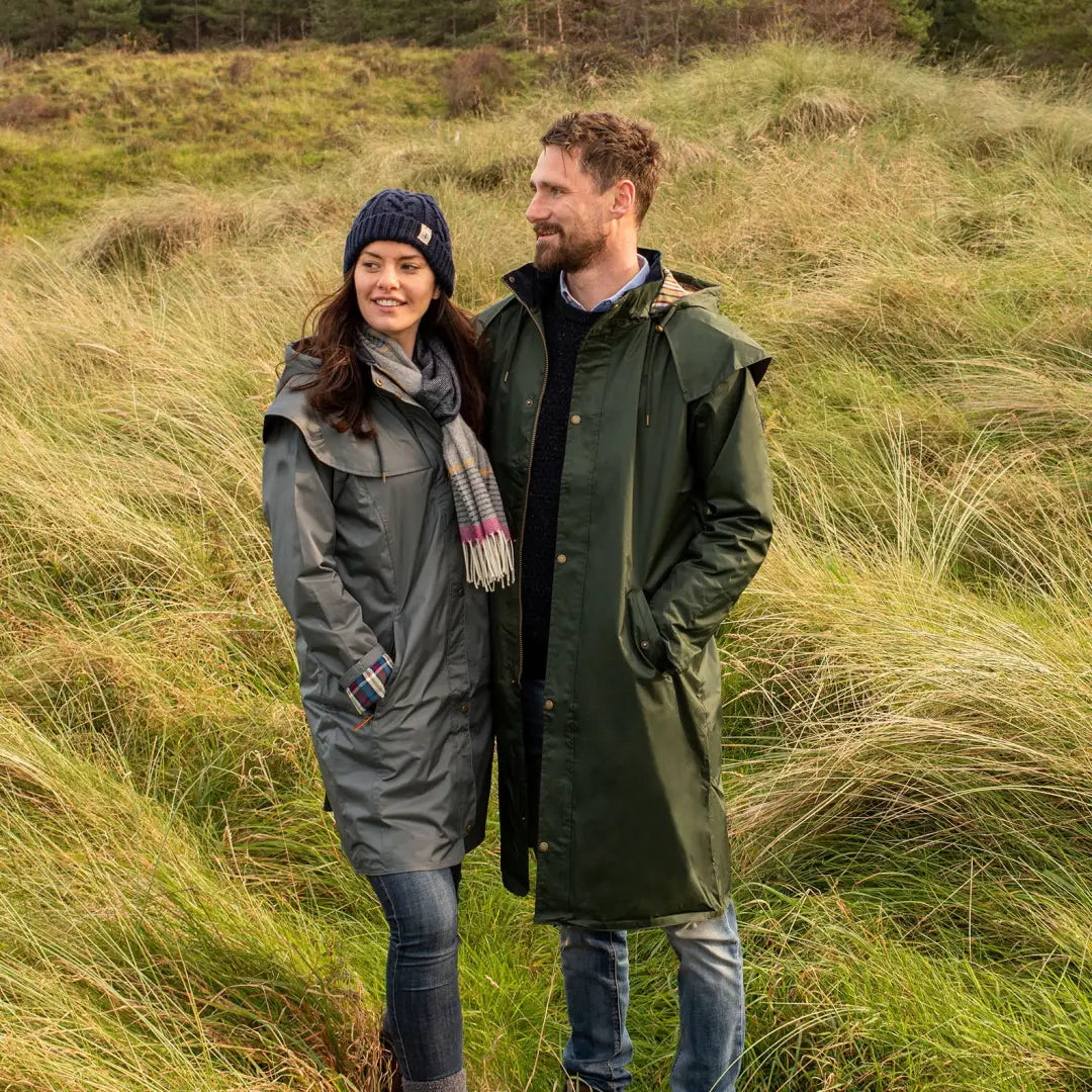 Couple in Lighthouse Stockman Full Length Waterproof Rain Coat standing in tall grass