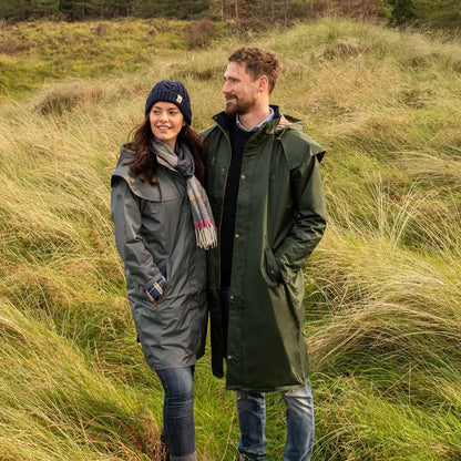 Couple in Lighthouse Stockman Full Length Waterproof Rain Coat standing in tall grass