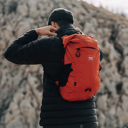 Person wearing an orange Mac in a Sac Travelite Backpack for stylish adventures