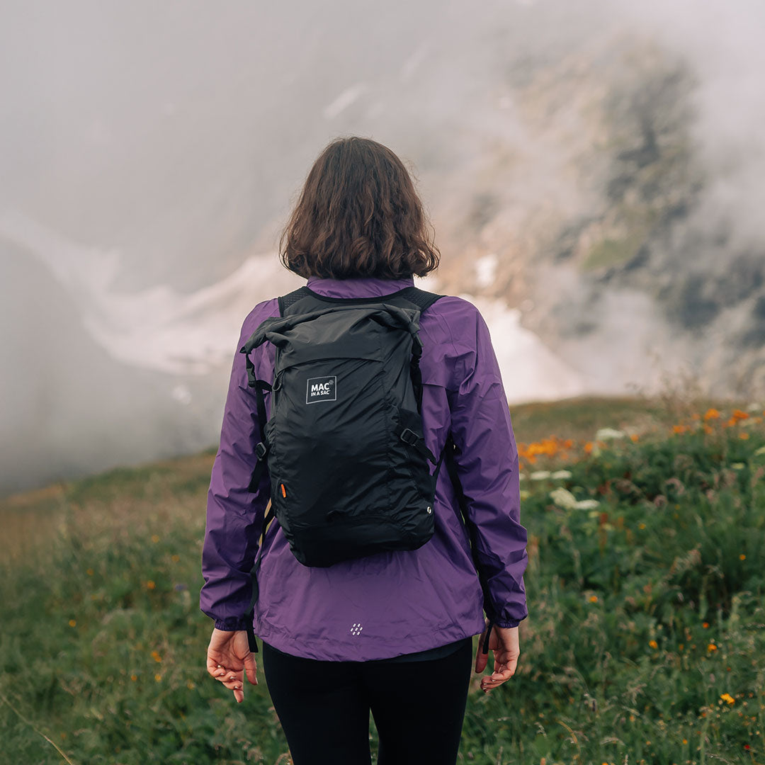 Black backpack on a person wearing the Mac in a Sac Travelite Backpack for travel