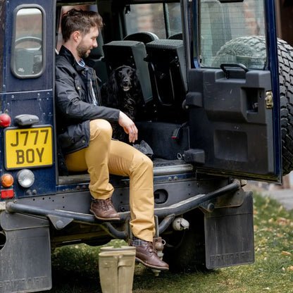 Land Rover with a person and dog, rocking a Mens Biker Wax Jacket in the wild