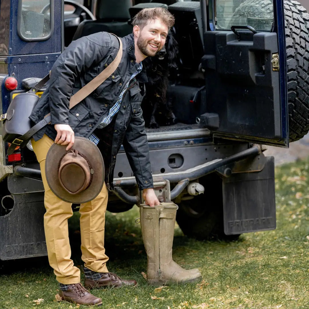 Rugged off-road vehicle with a person stepping out in a Mens Biker Wax Jacket