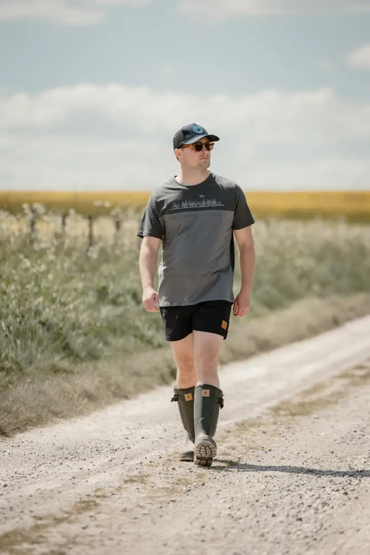 Man in boots walking on dirt road wearing New Forest 2-Tone Graphic T-Shirt in forest clothing graphic