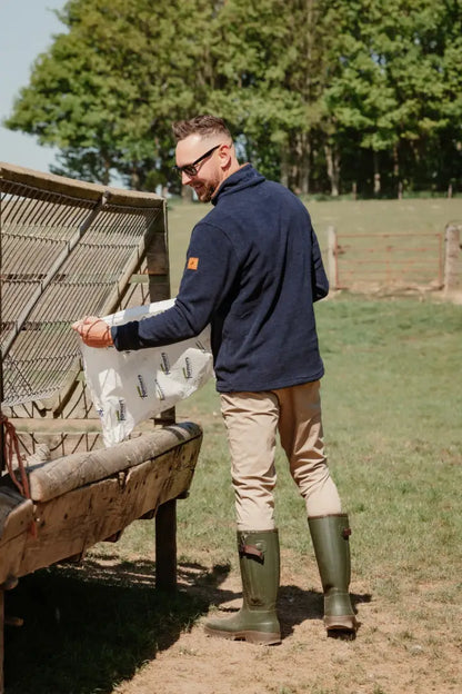 Man wearing New Forest Avon zip wellington boots feeding livestock outdoors
