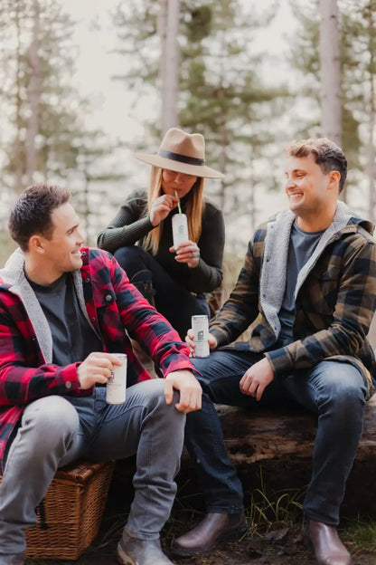 Three friends enjoying drinks in a Green Lumberjack Shirt, perfect for forest adventures