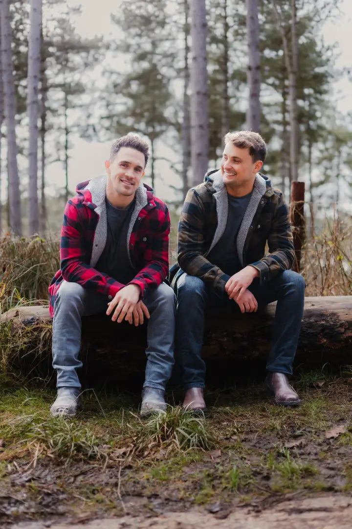 Two men relaxing on a log in their Forest Canadian Sherpa shirts