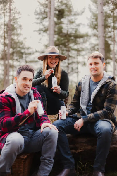 Three friends enjoying drinks in a stylish green lumberjack shirt, the Forest Canadian Sherpa