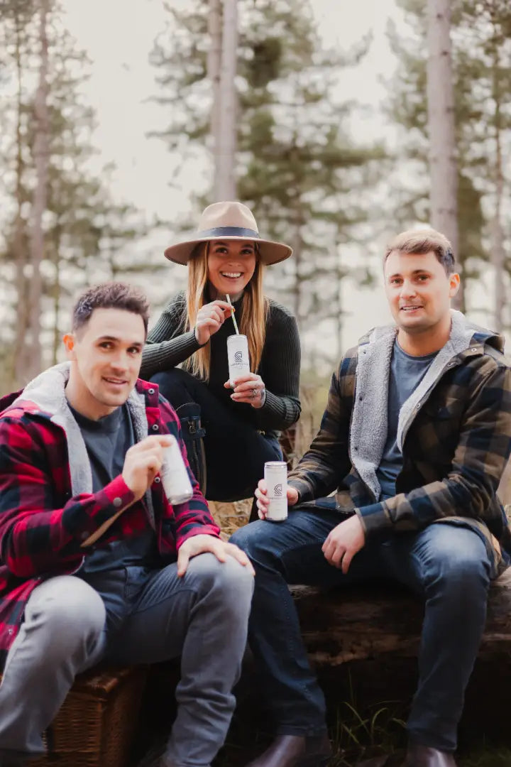 Three friends enjoying drinks in a stylish green lumberjack shirt, the Forest Canadian Sherpa