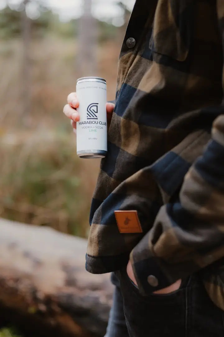White can of sparkling wine next to a stylish Forest Canadian Sherpa Shirt