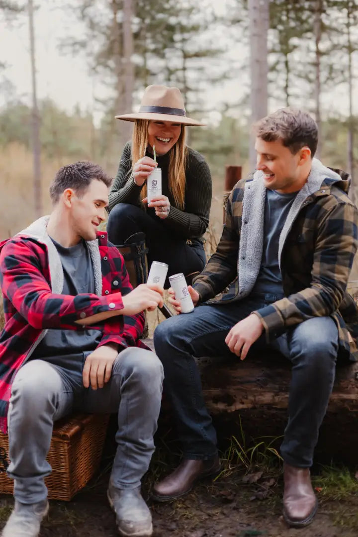 Three friends toasting drinks outdoors in a Forest Canadian Sherpa Shirt