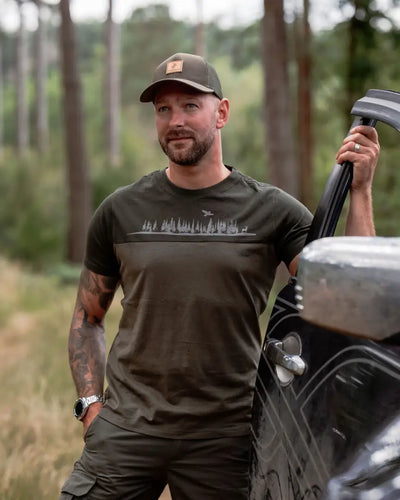 Man in olive green outdoor apparel wearing New Forest Country Sport Trucker Hat, an iconic trucker hat