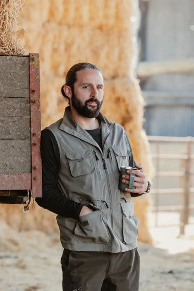 Man in a vest enjoying coffee, showcasing the New Forest Explorer Gilet for explorers