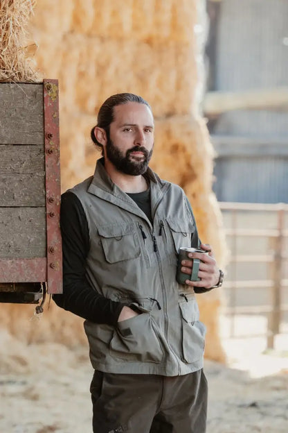 Man in a vest enjoying coffee, showcasing the New Forest Explorer Gilet for explorers