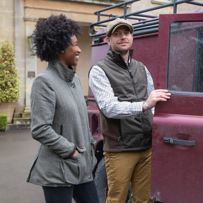 Two people by a maroon Land Rover in New Forest Grouse Padded Gilet for added warmth