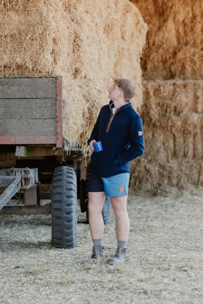 Man in farm setting wearing New Forest Harlequin Rugby Shorts, perfect country clothing for hunting