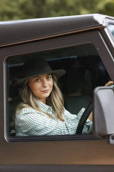 Woman with a wide brim Forest Harrison Waxed Hat driving a car in style