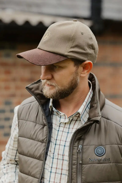 Man in a brown cap and vest showcasing the New Forest Heated Gilet