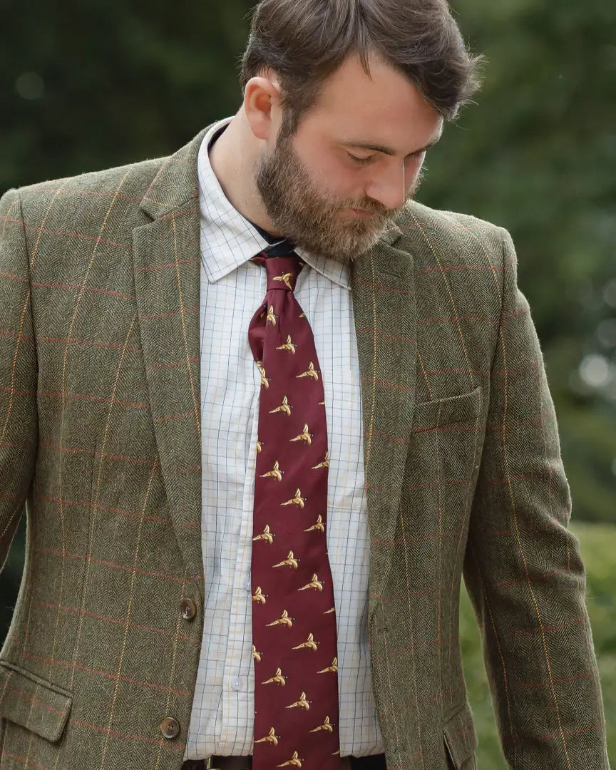 Man in forest heritage tweed blazer with white patterned shirt and burgundy pheasant tie