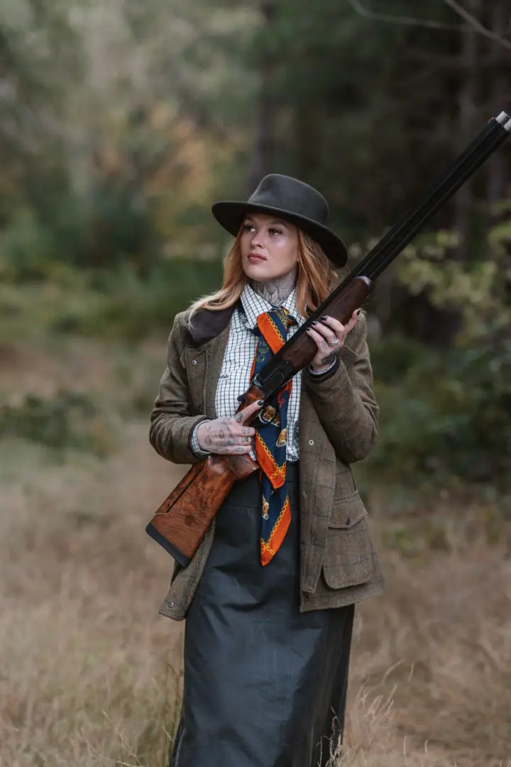 Super stylish ladies field coat featuring a woman in hunting attire with an over-and-under shotgun