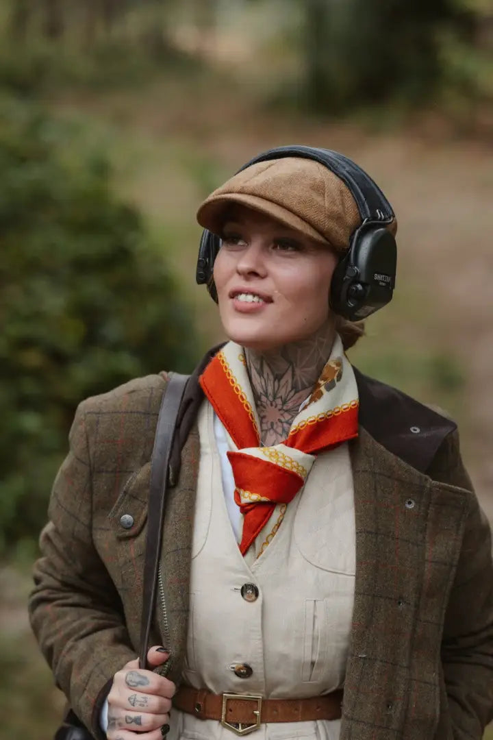 Super stylish ladies field coat featuring a woman in a tweed jacket, cap, and ear protection