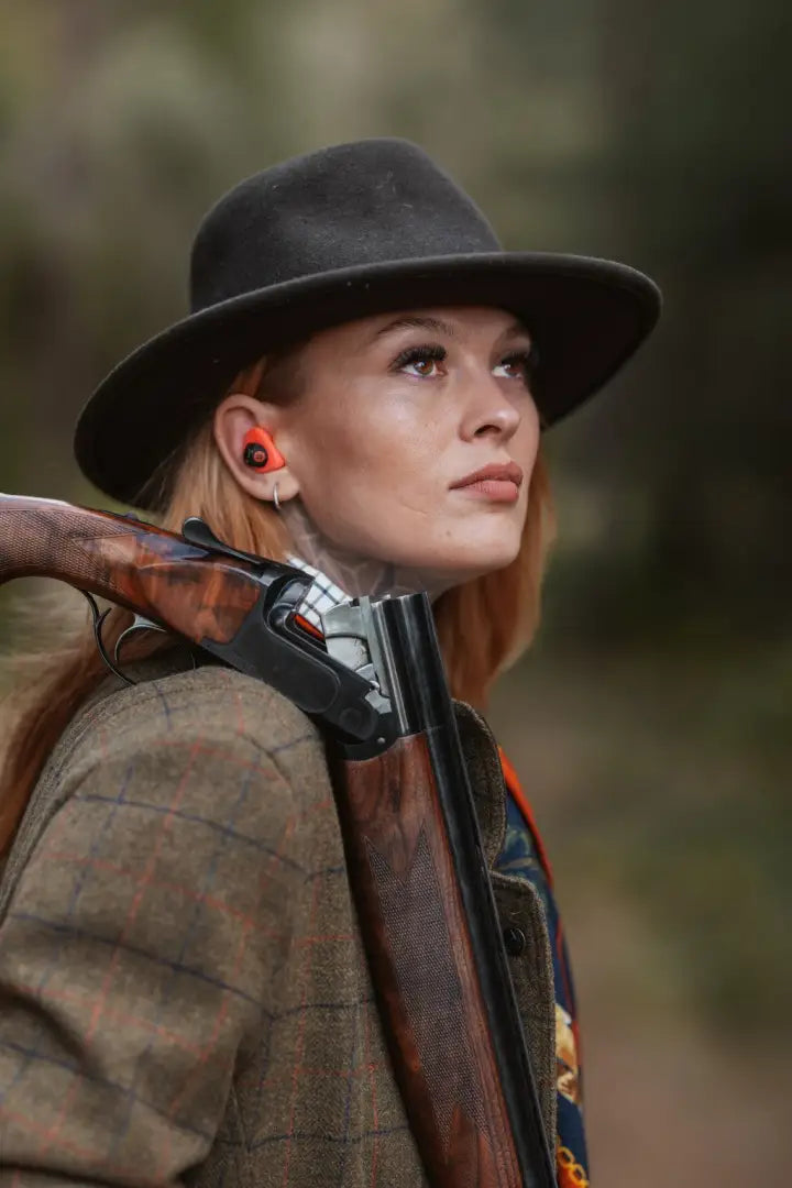 Super stylish ladies field coat featuring woman in hunting hat with shotgun and ear protection