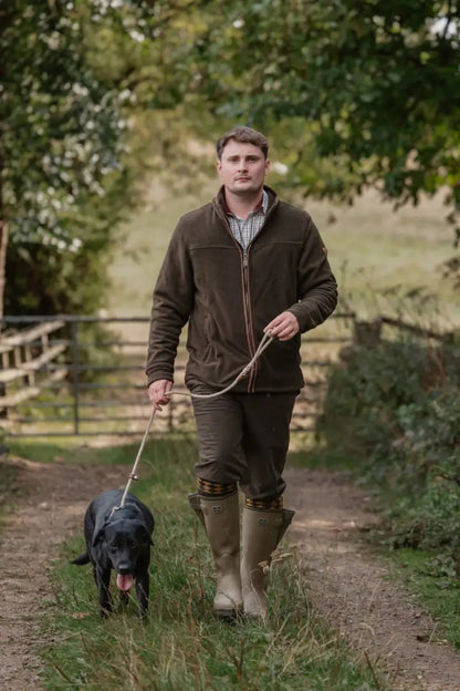Man walking black Labrador in forest knightwood zip fleece embodying total comfort outdoors