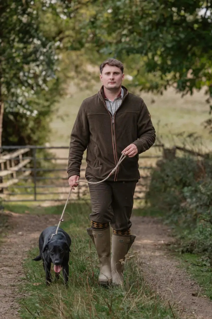 Man walking black Labrador in forest knightwood zip fleece embodying total comfort outdoors